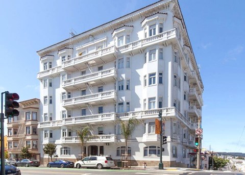 a white apartment building on the corner of a street