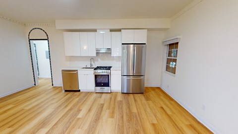 a kitchen with white cabinets and a stainless steel refrigerator