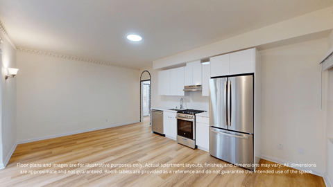 A kitchen with a stainless steel refrigerator and wooden flooring.