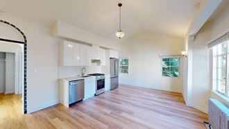 an empty kitchen with white cabinets and a wood floor