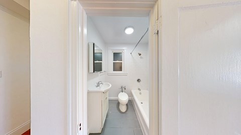 A bathroom with a toilet, sink, and mirror.