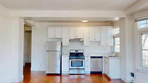 A kitchen with white cabinets and stainless steel appliances.