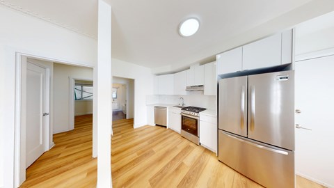 A kitchen with a refrigerator and an oven.