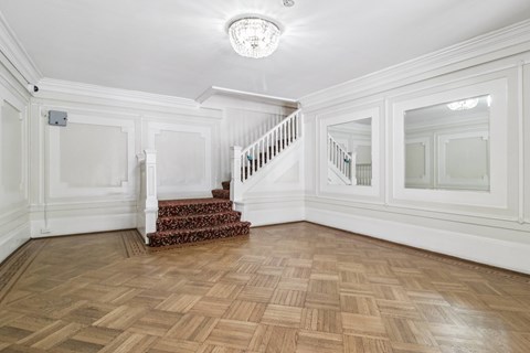 A room with a staircase and a chandelier.