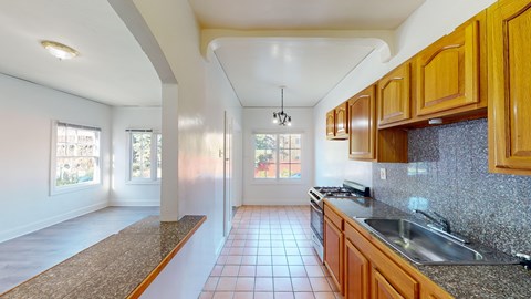 A kitchen with wooden cabinets and a tiled floor.