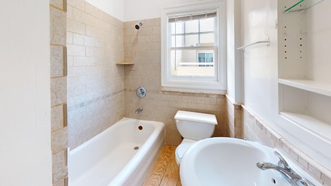 A bathroom with a tub, toilet, and sink.