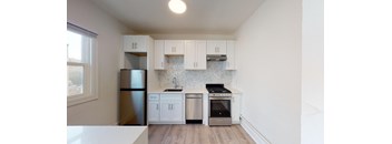 a kitchen with white cabinets and stainless steel appliances