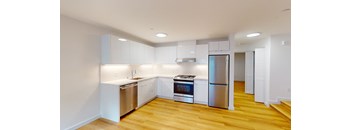 a renovated kitchen with white cabinets and stainless steel appliances