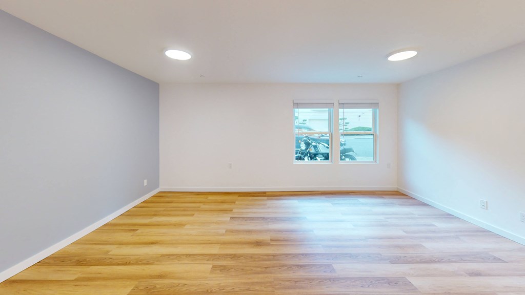an empty living room with white walls and wooden floors