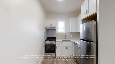 A kitchen with white cabinets and a stainless steel refrigerator.