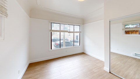 A room with a window and wooden flooring.
