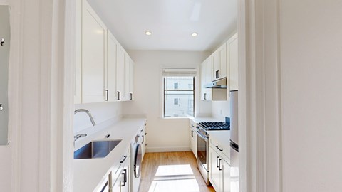 A modern kitchen with white cabinets and appliances.