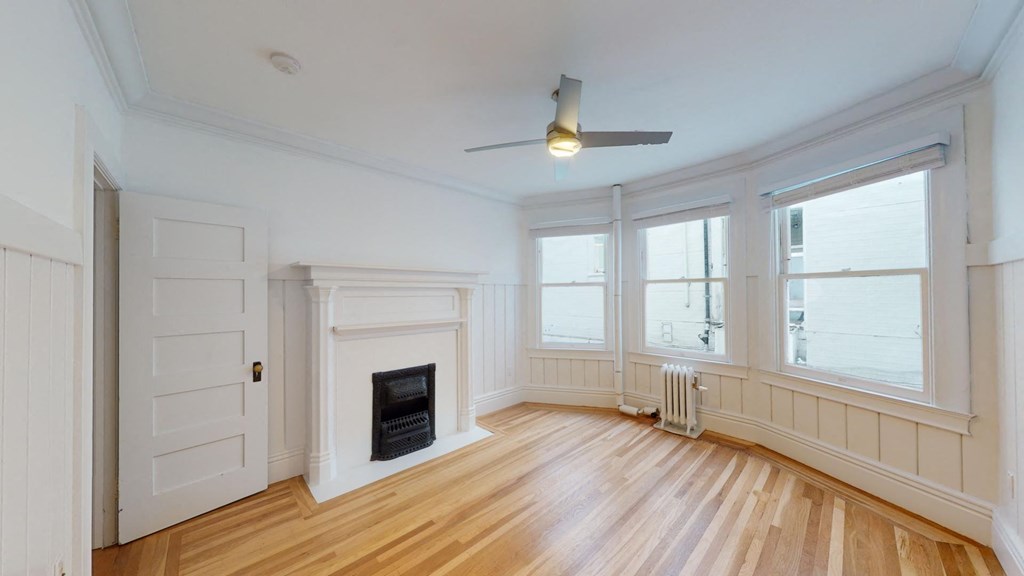 an empty living room with a fireplace and windows