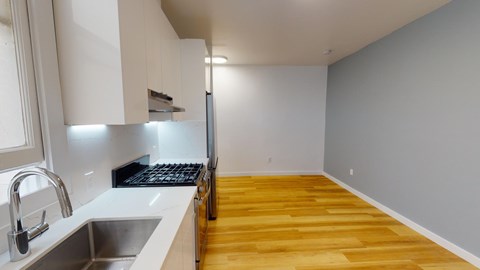 Kitchen with cabinets, refrigerator, stove, range hood, and sink