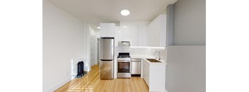 a kitchen with white cabinets and a stainless steel refrigerator