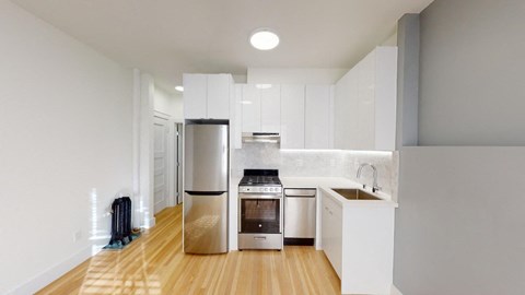 a kitchen with white cabinets and a stainless steel refrigerator