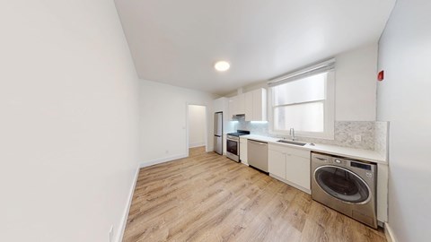 A kitchen with a washing machine built into the counter.