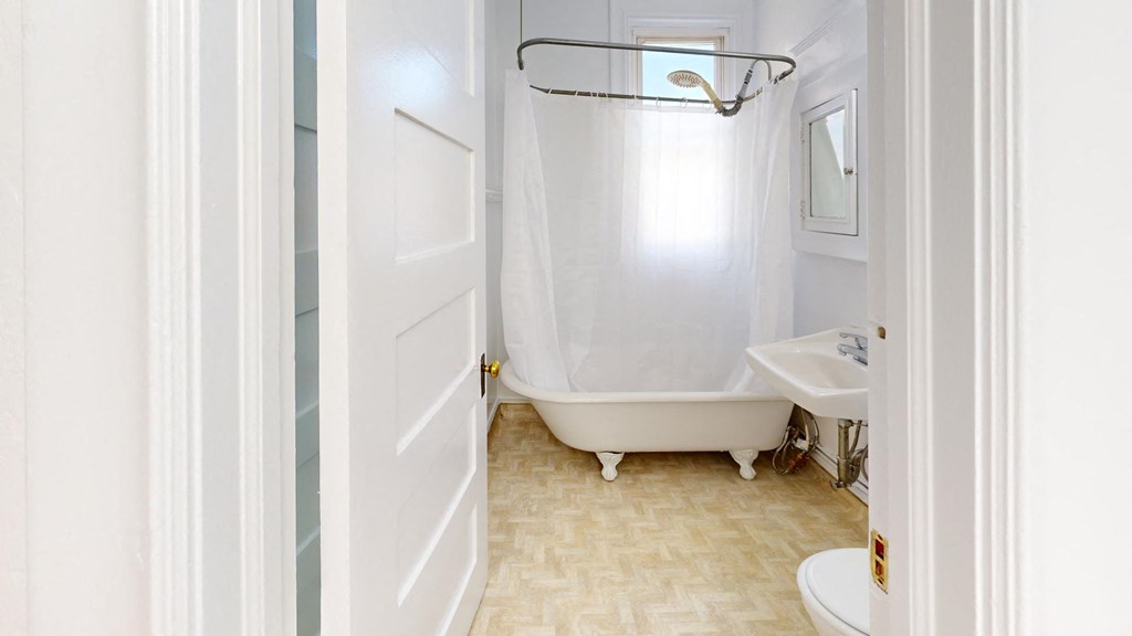 a bathroom with a tub and a shower and a sink