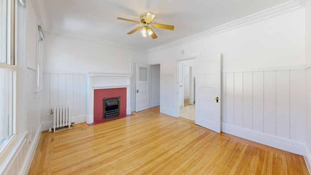a living room with a fireplace and a ceiling fan