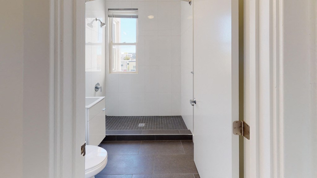 a white bathroom with a shower and a sink