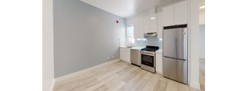 a kitchen with white cabinets and stainless steel appliances