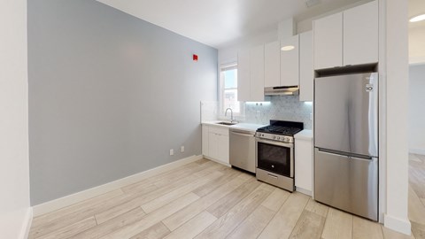 a kitchen with white cabinets and stainless steel appliances