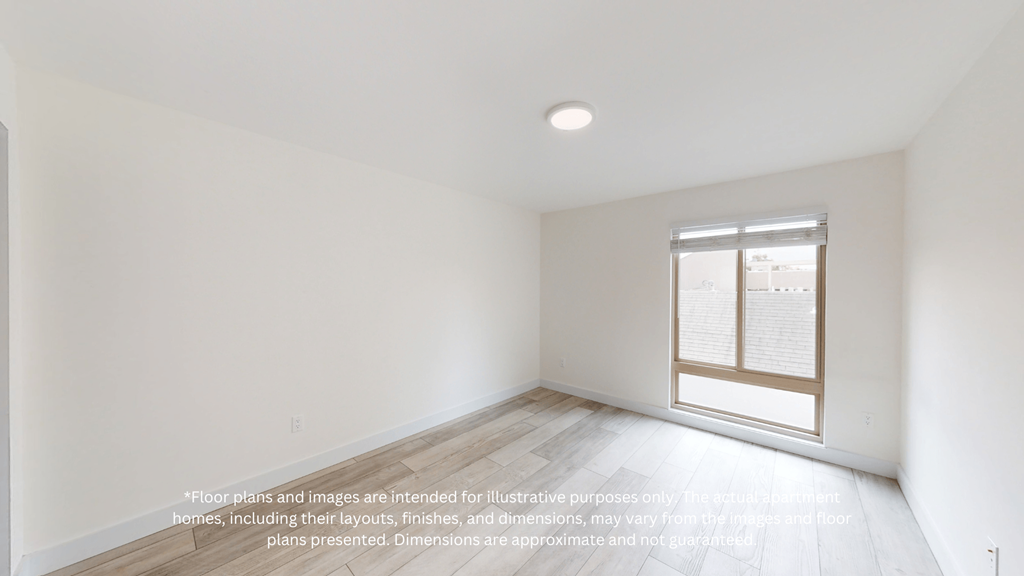 an empty room with white walls and wood floors and a window