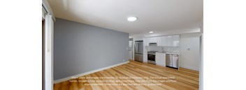 a view of a kitchen with a wood floor and white cabinets