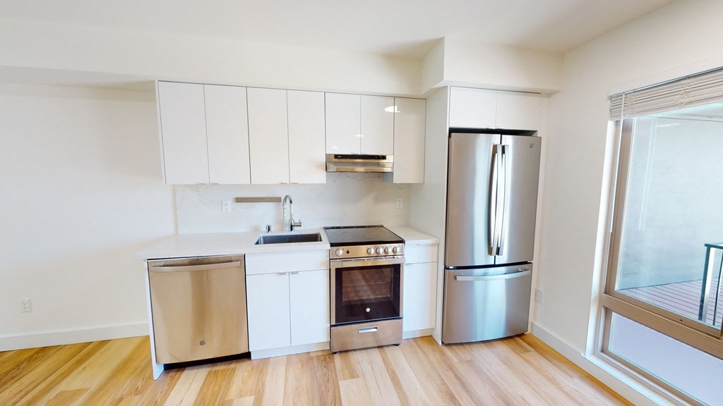 a kitchen with white cabinets and stainless steel appliances