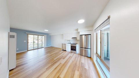 A kitchen with wooden floors and stainless steel appliances.