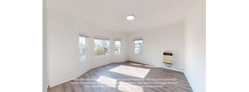 an empty living room with three windows and a wood floor