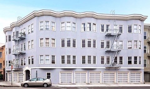 a white building with a car parked in front of it