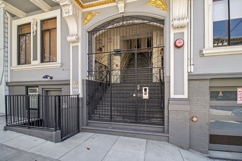 A black wrought iron gate blocks the entrance to a building.