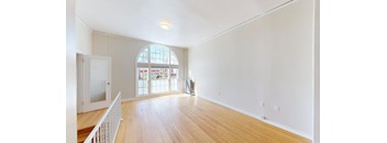 a living room with a large window and a wooden floor