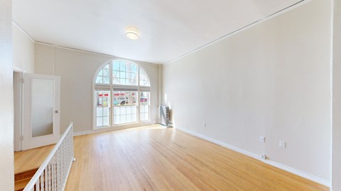 a living room with a large window and a wooden floor