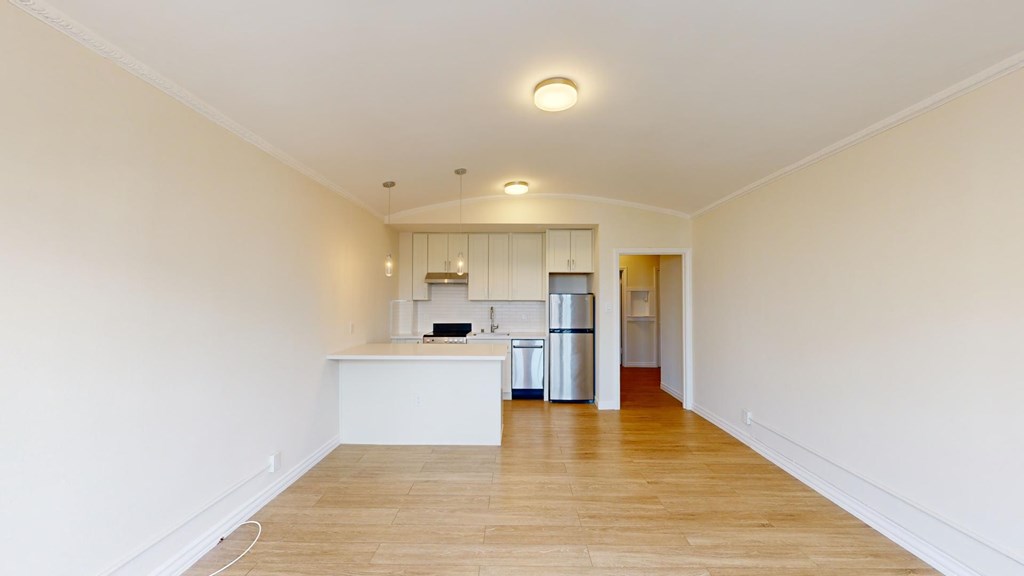 A kitchen with white cabinets and a white island with a sink.