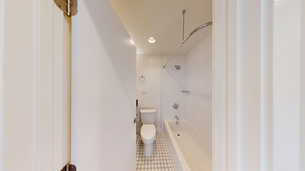 A white bathroom with a toilet, sink, and bathtub.