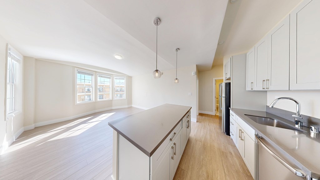 A kitchen with a wooden floor and white walls.