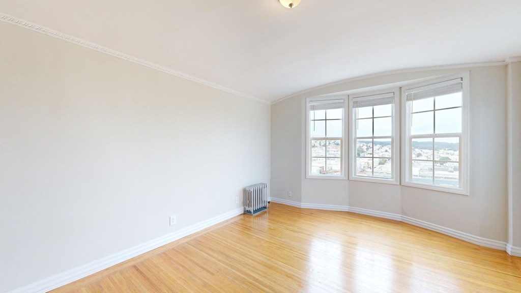 an empty living room with white walls and a wood floor