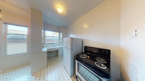 A kitchen with a black stove top oven and white tiled flooring.
