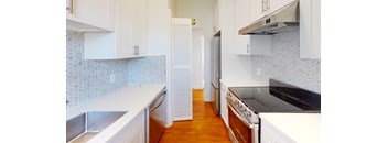 a kitchen with white cabinets and a stove and a refrigerator