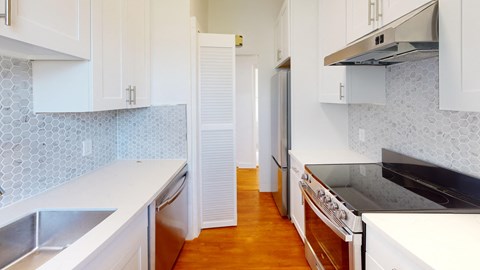 a kitchen with white cabinets and a stove and a refrigerator