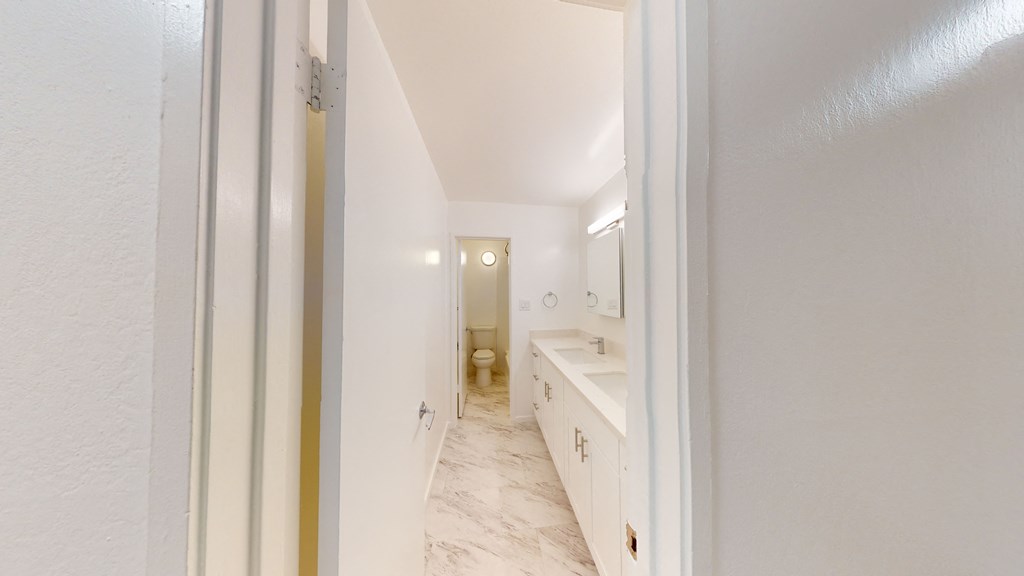 a bathroom with white cabinets and a sink and a toilet