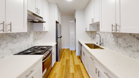 a kitchen with white cabinets and a stove and a sink