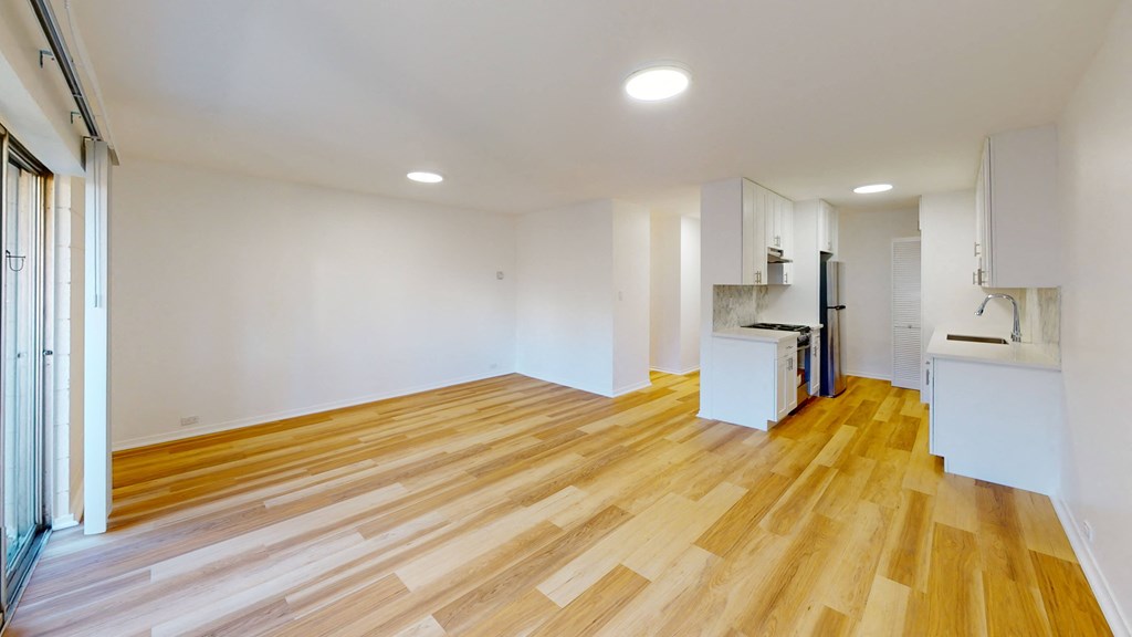 a living room with a hard wood floor and a kitchen