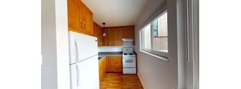 a small kitchen with wooden cabinets and a window