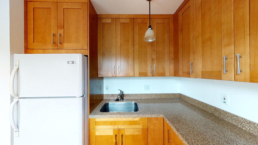 a kitchen with wooden cabinets and a sink and a refrigerator