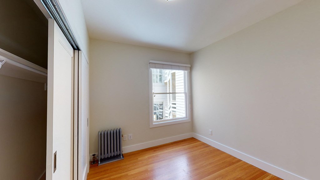 an empty room with wood floors and a window