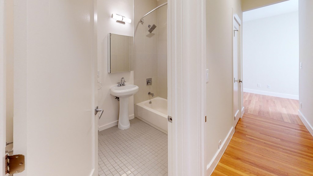 a bathroom with a tub and a sink and a mirror