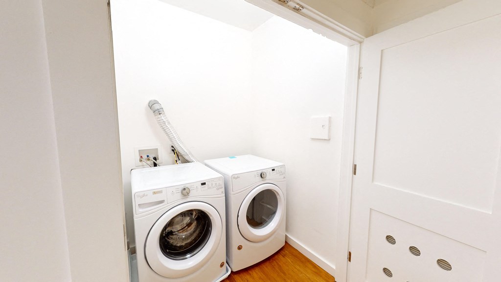 a white washer and dryer in a white laundry room